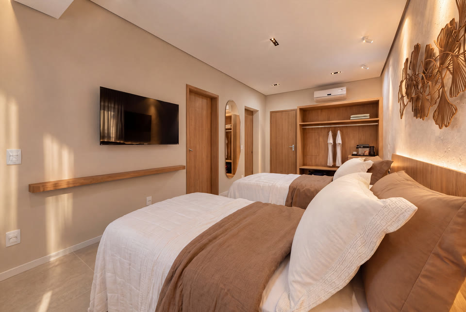 Quarto com camas de solteiro, TV de parede e armário de madeira